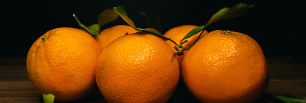 Oranges,On,A,Wooden,Board,On,A,Black,Background.,Front